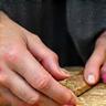 Symbol für Massfertigung: Ein handwerker hobelt Holz